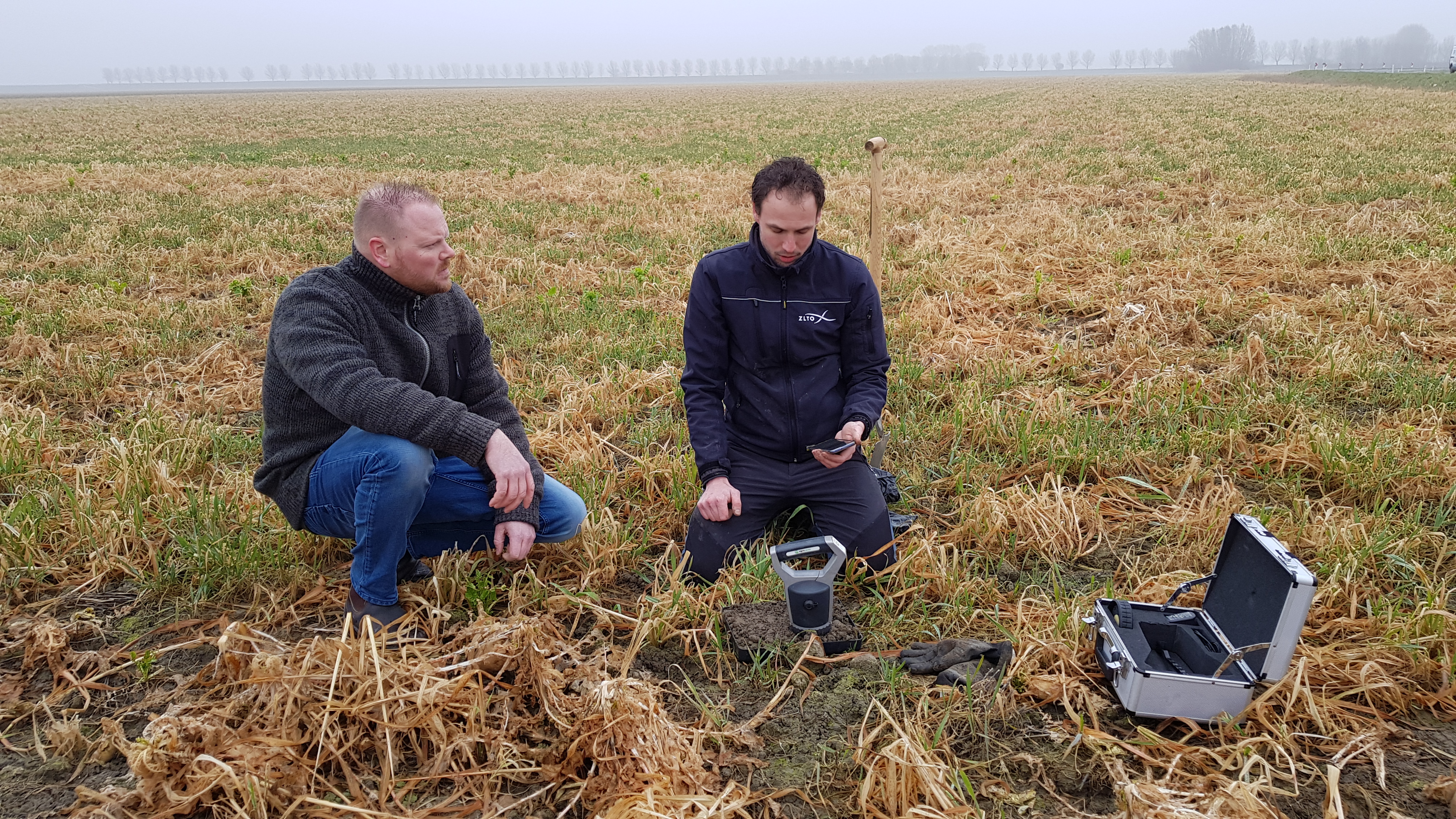 Carbon farming expert determining the organic matter content in the soil using a soil scanner